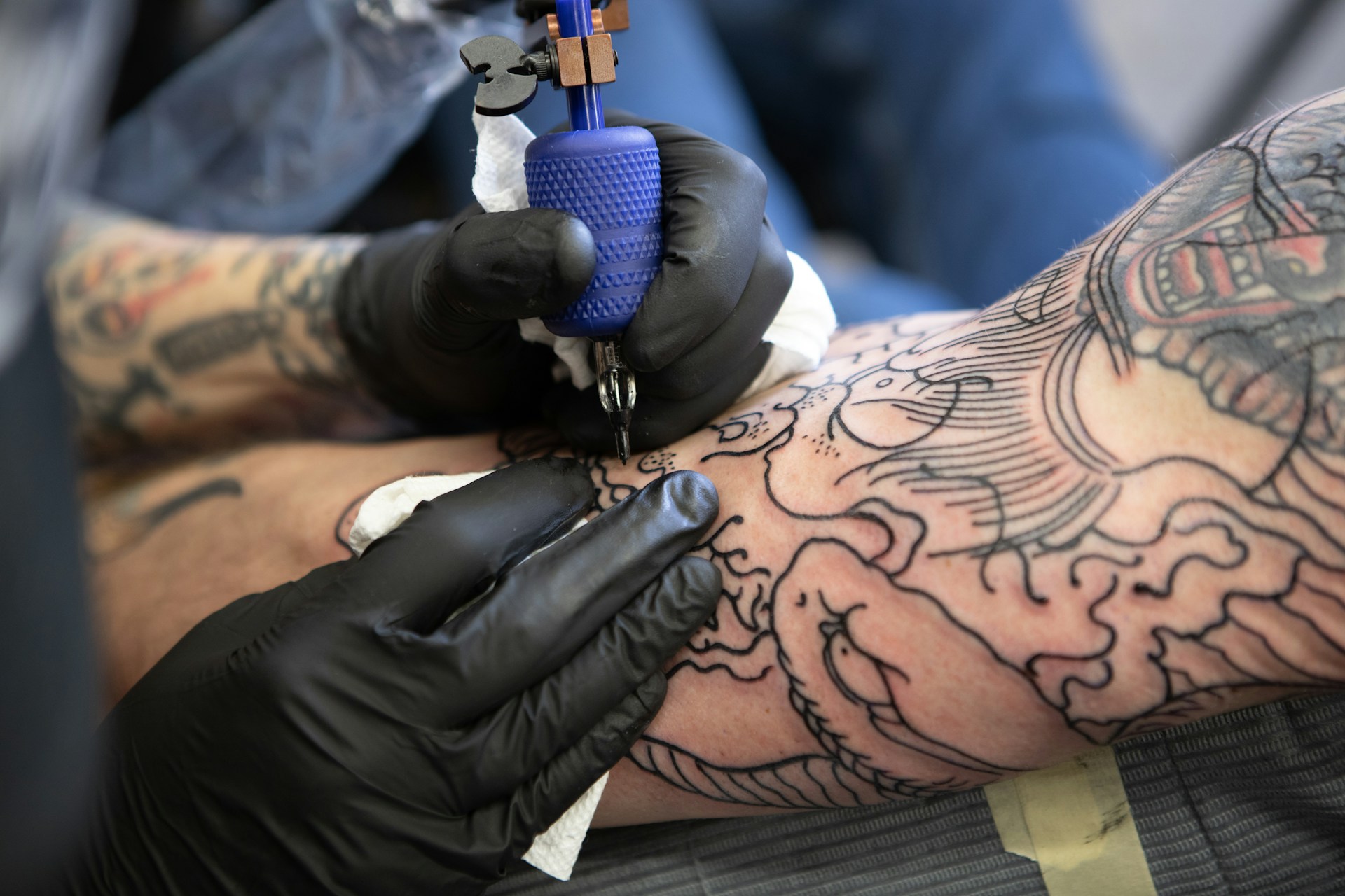 close-up of a tattoo artist giving someone a tattoo